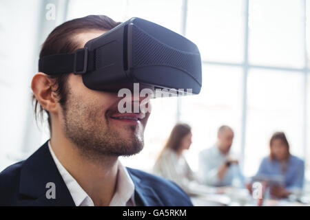 Smiling businessman en utilisant le simulateur de réalité virtuelle Banque D'Images