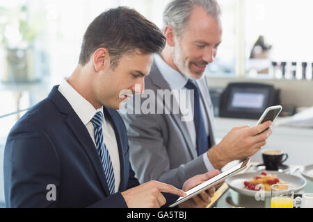 Deux hommes d'affaires à l'aide de téléphone mobile et tablette numérique Banque D'Images