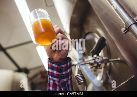 Man holding beer mug par les machines Banque D'Images