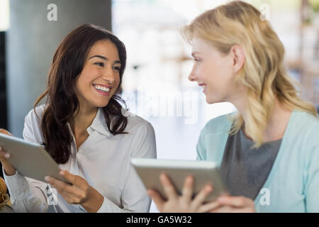 Deux belles femmes en interaction les uns avec les autres pendant l'utilisation d'ordinateur portable Banque D'Images