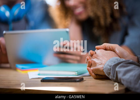 Businessman with hands clasped in office Banque D'Images