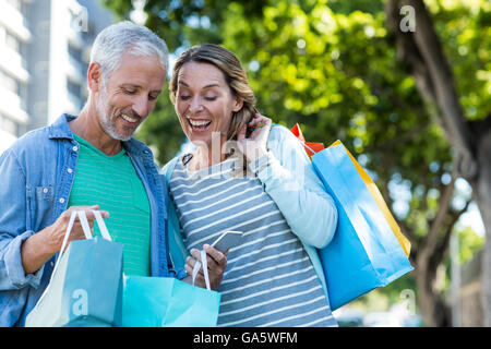 Heureux couple with shopping bags in city Banque D'Images