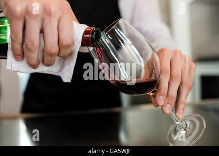 Barman pouring wine in glass Banque D'Images