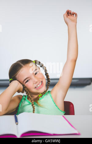 Portrait de lycéenne levant la main en classe Banque D'Images