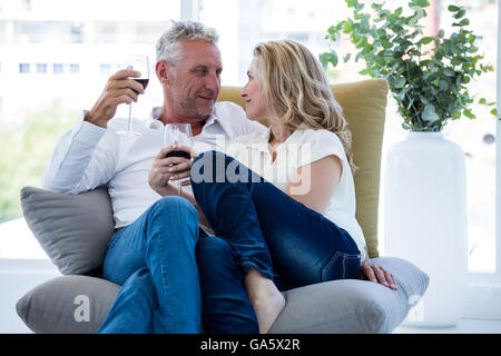 Couple romantique ayant le vin rouge à la maison Banque D'Images