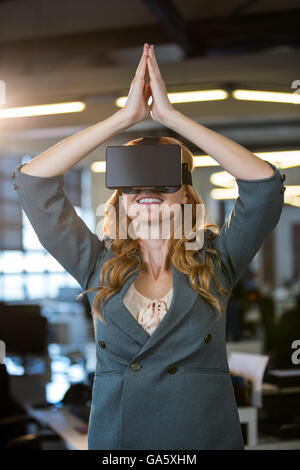 Businesswoman les mains jointes à l'aide d'un simulateur de réalité virtuelle Banque D'Images