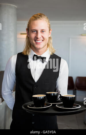 Waiter holding un plateau avec les tasses de café dans le Banque D'Images