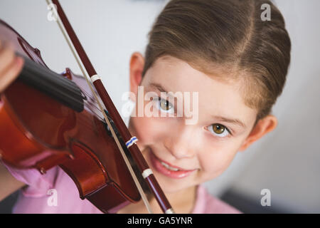 Portrait of smiling schoolgirl à jouer du violon en classe Banque D'Images