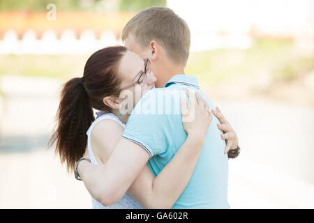 Beau jeune couple romantique en rapport réunion ou se séparer dans la rue et serrant étroitement les uns les autres avec affection Banque D'Images