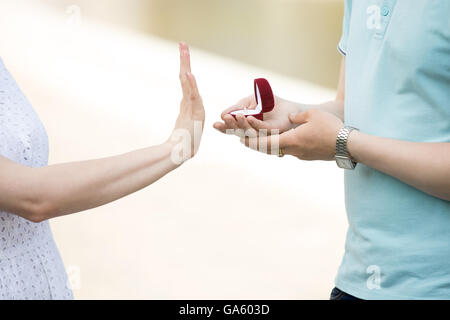 Close-up de main de jeune femme tournant vers le bas de la proposition d'engagement. Handsome man holding red fort avec bague de fiançailles Banque D'Images