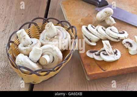 Les champignons frais sur planche de bois à l'aide d'un couteau Banque D'Images