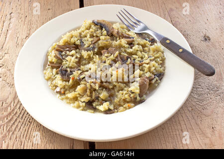 Risotto aux champignons sur la plaque avec une fourchette Banque D'Images