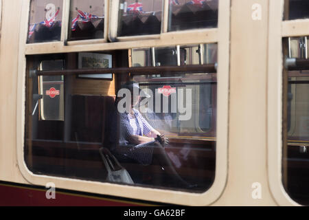 Une élégante dame mature dans la fenêtre d'un train à vapeur Banque D'Images