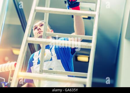 Peintre chambre standing avec rouleau de peinture. La préparation de la chambre de peinture. Banque D'Images