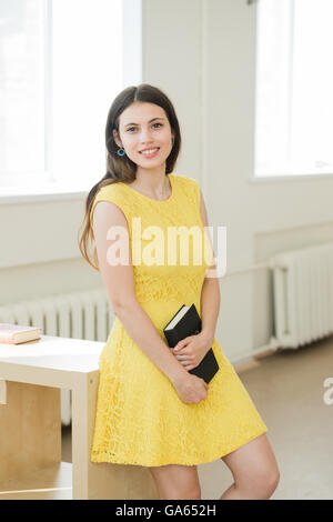 Happy young smiling student girl avec réserve. Banque D'Images