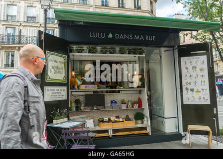 Paris, France, French Kiosque, Street Vendor, dans le Marais, concierge Services, « Lulu dans ma rue » Homme marchant en face, quartiers locaux Banque D'Images