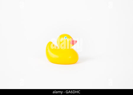 L'enfant d'un jouet de bain canard en caoutchouc sur un fond blanc. Banque D'Images