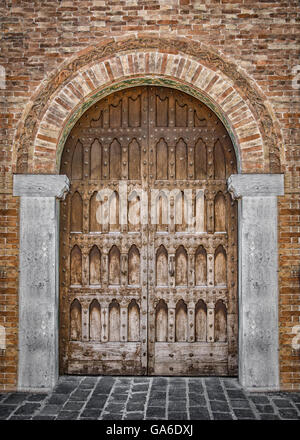 Entrée voûtée d'un palais médiéval avec porte en bois sculpté. Banque D'Images