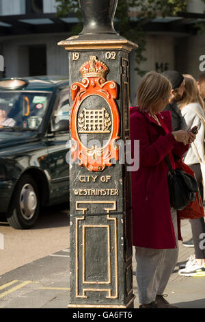 Londres, Angleterre, Royaume-Uni - 25 septembre 2015 : Pied de lampe de rue avec le blason de la ville de Westminster Banque D'Images