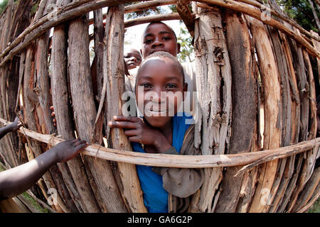 Un garçon regarde à travers la clôture dans l'orphelinat "que les petits enfants viennent à moi" près de la ville de Butanre au Rwanda. Banque D'Images