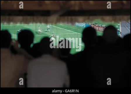 Les gens regardent l'équipe de soccer en France jouer la Coupe du Monde sur écran géant à La Défense, France, juin 2002 Banque D'Images