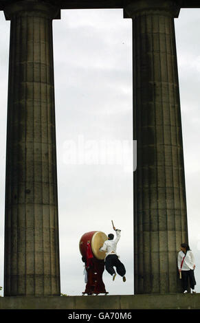 Tuek Hu Ha, un batteur coréen traditionnel de Dulsori, se produit avec son tambour de 2 mètres de haut dans le cadre de son Edinburgh Festival Fringe Act sur Calton Hill, à Édimbourg. Banque D'Images