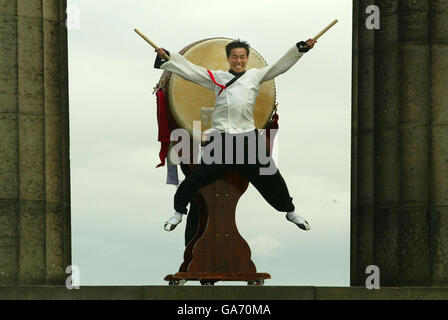 Tuek Hu Ha, un batteur coréen traditionnel de Dulsori, se produit avec son tambour de 2 mètres de haut dans le cadre de son Edinburgh Festival Fringe Act sur Calton Hill, à Édimbourg. Banque D'Images