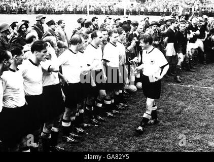 (G-D) Horst Eckel, Helmut Rahn, Ottmar Walter, Werner Liebrich, Josef Posipal, Hans Schafer, Werner Kohlmeyer, Karl Mai et Max Morlock regardent le capitaine de meute Fritz Walter revenir à la ligne après avoir remporté le Trophée Jules Rimet après la victoire de son équipe sur la Hongrie en 3-2, qui regarde de manière décevante Banque D'Images