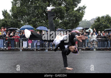 Un danseur de brebis joue dans le défilé tandis que les spectateurs brave la pluie tandis que le festival annuel de Cavalcade d'Édimbourg traverse les rues de la capitale écossaise. Banque D'Images