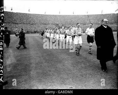 Les deux équipes sortent à Wembley pour la finale de la coupe FA, avec Liverpool dirigé par le capitaine Phil Taylor (deuxième r) et Arsenal dirigé par le capitaine Joe Mercer (troisième r) Banque D'Images