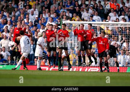 Ian Harte (l), de Leeds United, tente de courber un franc-pied Autour du mur défensif de Manchester United Banque D'Images