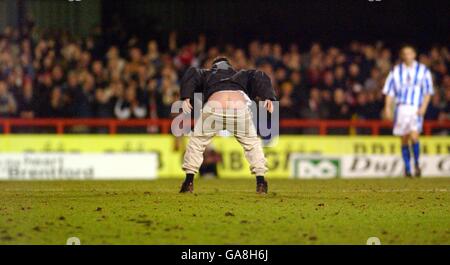 Football - Nationwide League Division Two - Brentford / Brighton & Hove Albion.Un supporter de Brentford envahit le terrain et montre ce qu'il pense de Brighton & Hove Albion aux fans de l'extérieur Banque D'Images