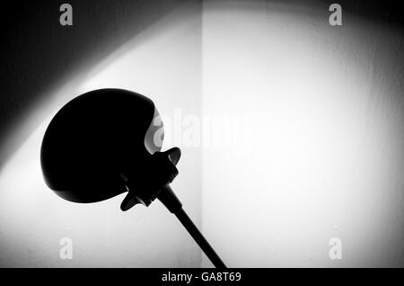 Lampe de bureau éclaire le coin de la chambre peinte en blanc. La lumière et les ombres sur place Banque D'Images