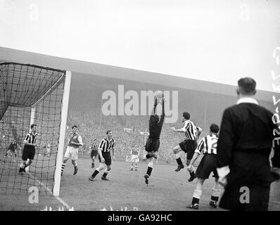 Le gardien de but de Newcastle United Ronnie Simpson (quatrième l) saute pour intercepter une croix, sous la surveillance de Ted Robledo (troisième l) et Cliff Holton d'Arsenal (deuxième l) Banque D'Images