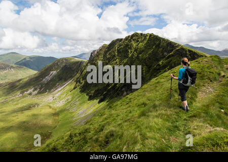 Une femme voyageant seule walker sur l'Nantle Ridge dans le Parc National de Snowdonia, le Nord du Pays de Galles. Banque D'Images