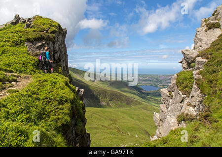 Une femme voyageant seule walker sur l'Nantle Ridge dans le parc national de Snowdonia , au nord du Pays de Galles. Grâce à un écart vers la côte. Banque D'Images