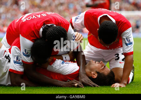 Francesc Fabregas (sur le terrain) d'Arsenal célèbre le quatrième but du jeu, avec ses coéquipiers Kolo Toure, Emmanuel Adebayor et Theo Walcott. Banque D'Images