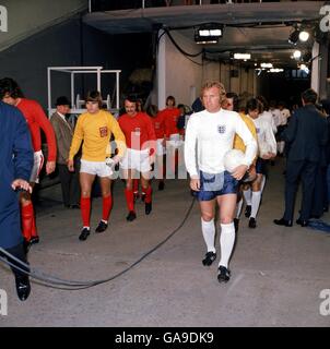 Le capitaine du pays de Galles Mike England (FAR l), aux côtés du capitaine de l'Angleterre Bobby Moore (r), dirige son équipe à Wembley, suivi des coéquipiers John Phillips (deuxième l) et Peter Rodrigues (troisième l) Banque D'Images