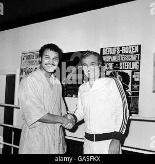 (G-D) le champion du monde de poids léger et lourd John Conteh serre les mains avec son entraîneur, George Francis Banque D'Images