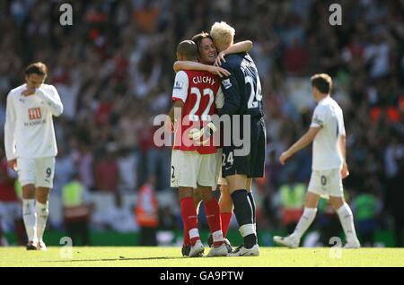 Football - Barclays Premier League - Tottenham Hotspur v Arsenal - White Hart Lane.Les joueurs d'Arsenal célèbrent la victoire après le coup de sifflet final alors que les joueurs de Tottenham Hotspur sont découragés Banque D'Images