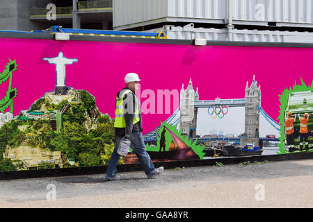 Stratford London, UK. 5 août 2016. Un travailleur de la construction passe devant une peinture murale montrant le Christ Rédempteur à Rio à côté de Tower Bridge avec les anneaux olympiques que Rio de Janeiro se prépare à accueillir les Jeux Olympiques de 2016 à la suite de London Crédit : amer ghazzal/Alamy Live News Banque D'Images