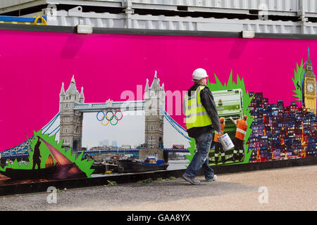 Stratford London, UK. 5 août 2016. Un travailleur de la construction passe devant une peinture murale montrant le Christ Rédempteur à Rio à côté de Tower Bridge avec les anneaux olympiques que Rio de Janeiro se prépare à accueillir les Jeux Olympiques de 2016 à la suite de London Crédit : amer ghazzal/Alamy Live News Banque D'Images