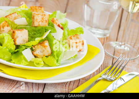Une assiette avec une salade fraîche sur une table rustique dans une lumière vive. Banque D'Images