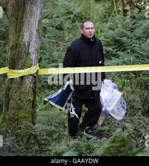 Un policier avec des preuves sur les lieux après l'hélicoptère dans lequel Colin McRae volait s'est écrasé, près de sa maison sur Larakshire. Banque D'Images