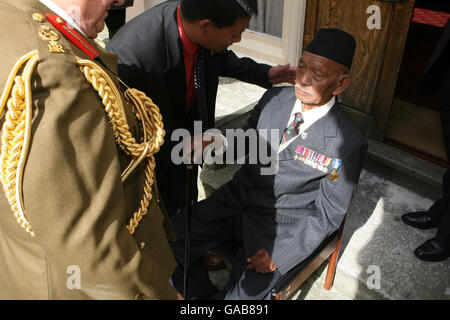 L'ancien lieutenant Gurkha Tul Bahadur Pun, qui a reçu la Croix de Victoria pour ses héroïques pendant la Seconde Guerre mondiale, est aidé par son ami Padam Limbu, alors que le Field-Marshall Sir John Chapple se tient à l'École militaire royale de musique de Twickenham, dans le sud-ouest de Londres. Banque D'Images