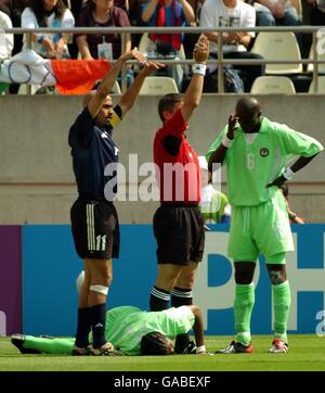 Football - coupe du monde de la FIFA 2002 - Groupe F - Argentine / Nigeria.L'arbitre Giles Veissière de France et le capitaine argentin Juan Veron appellent au physio comme Nigeria Nwankwo Kanu se trouve blessé sur le terrain Banque D'Images