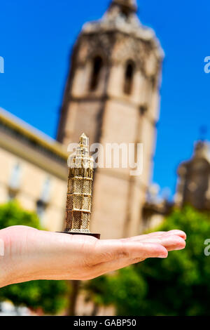 Une miniature du Micalet, le beffroi de la cathédrale de Valence, dans la main d'un homme en face du réel, en Micalet Valen Banque D'Images