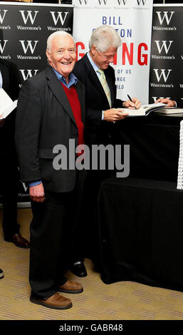 L'ancien président américain Bill Clinton signe des copies de son nouveau livre, « donner », pour l'ancien député Tony Benn à Waterstones, dans le centre de Londres. Banque D'Images