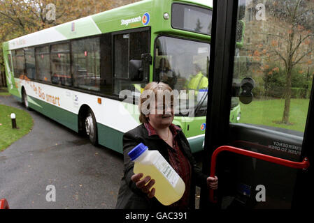 Une femme non identifiée tient un conteneur qui sera remis aux passagers à bord d'un bus pour qu'ils se remplissent d'huile de cuisson. En retour, elle recevra des tarifs réduits pour les bus, car Stagecoach lance les premiers Bio-bus du Royaume-Uni au parc Dean Castle à Kilmarnock. Banque D'Images