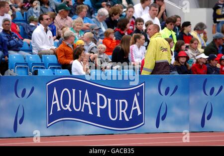 Athlétisme - épreuves du Commonwealth Aqua-Pura. Les fans regardent les événements derrière un tableau Aqua-Pura Banque D'Images